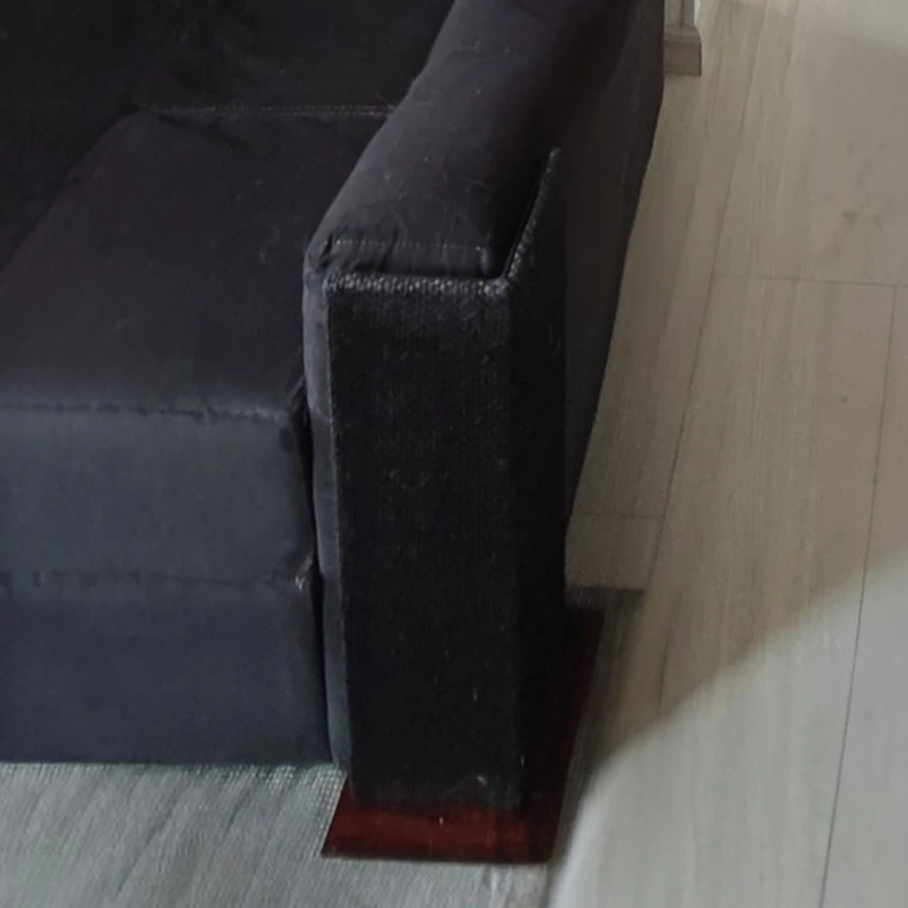 Esquinero protector de sofá para gatos en fique tintillado oscuro sobre sofá negro